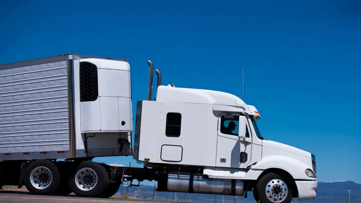 Reefer trailer with refrigeration unit mounted on the nose, hauled by a day-cab tractor